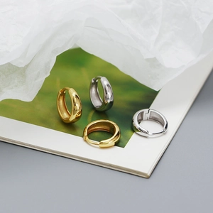 Polished S925 sterling silver hoop earrings in gold and silver finishes on a styled background