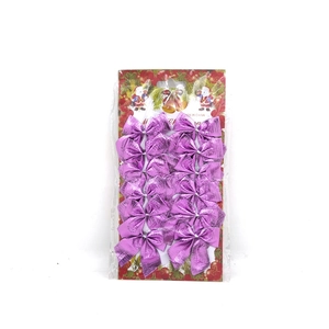Set of 12 purple metallic Christmas bows with glitter finish on festive card packaging
