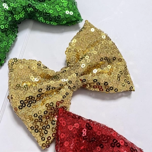 Macro detail of green, gold and red sequin bows showing texture and reflective finish