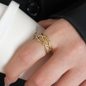 Close-up of golden multi-layer vine ring worn by model holding a minimalist cup