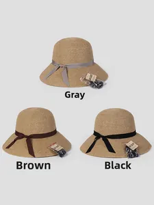Detailed view of straw sun hats in three colors with UV protection tags and wind ropes