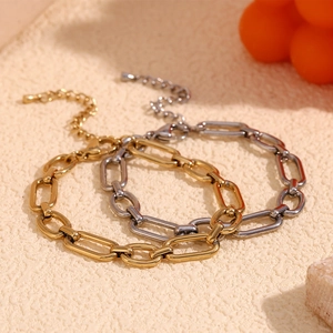 Bracelets trombones en acier inoxydable plaqué or 14K et argent sur fond beige