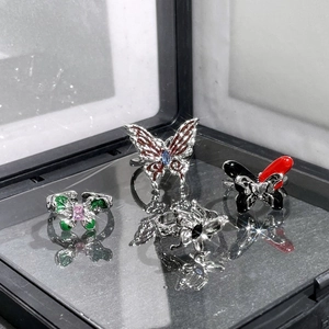 Set of colorful butterfly rings in silver metal with gemstone accents on black surface