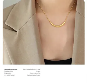 Gros plan d'un collier barre en acier titane plaqué or 18 carats sur un mannequin femme