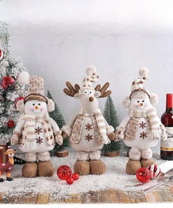 Dettaglio di tre bambole di Natale con ricami a fiocco di neve e sciarpe in maglia