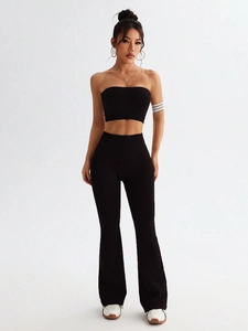 Detail view of black ribbed knit two-piece set featuring high waist flare pants and crop top