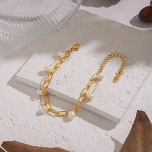 Detail of gold double-layer stainless steel bracelet with freshwater pearls and lobster clasp