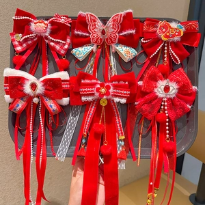 Detail of red festive bow hair clips with tassels and pearls on a display tray
