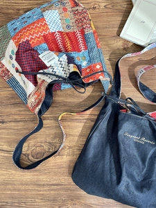 Bohemian patchwork shoulder bag and denim tote with embroidery on a wooden table