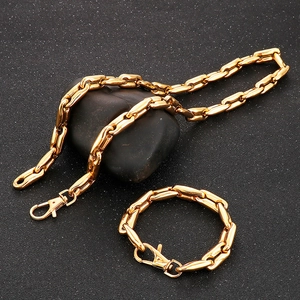 Golden stainless steel coffee bean link chain necklace and bracelet set on dark stone