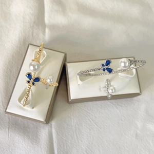 Detailed set of adjustable 18k gold plated butterfly bracelets and pearl rings in a box