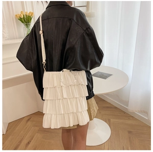 Detail of white ruffled layered shoulder bag with transparent acrylic round handle and strap