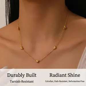 Close-up of golden stainless steel necklace with five heart charms worn on a model
