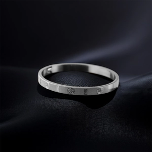 Detailed close-up of a silver titanium steel bracelet with textured geometric relief