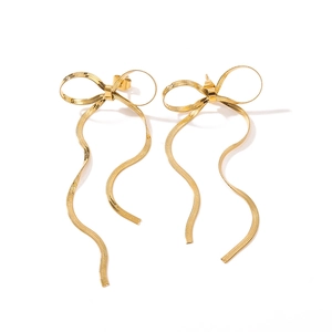 Golden stainless steel bow earrings with long wavy ribbon fringe on a white background