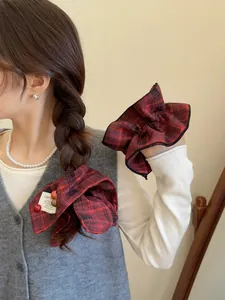 Detail of red and black plaid scrunchie with colorful beads on a low ponytail