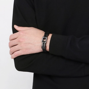 Detailed view of men's black woven leather bracelet with matte black square metal clasp
