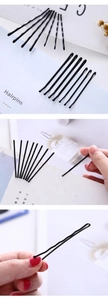 Detail of black metal hairpins with wavy structure and rounded tips for hairstyling