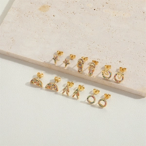 Macro shot of assorted gold star and moon stud earrings with colorful zircon inlay