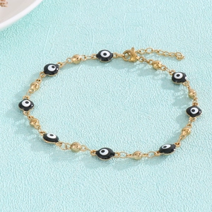 Detailed view of the gold Evil Eye bracelet with black and white enamel beads and lobster clasp