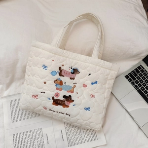 Détail du sac à main matelassé blanc avec broderie teckel mignonne et texte
