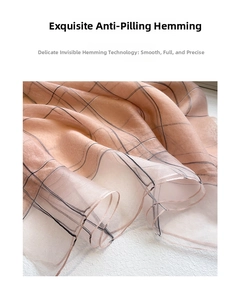 Detail shot of peach silk scarf featuring fine black grid pattern and precision stitching