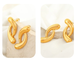 Macro detail of 18k gold plated twisted irregular geometric earrings on stone base