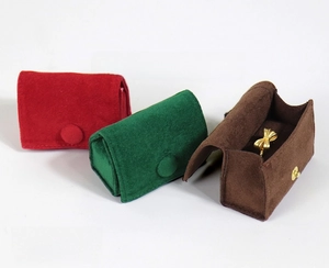 Velvet jewelry pouches in red, green, and brown with snap buttons and internal earbud holder