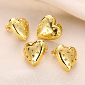 Macro shot of gold heart stud earrings featuring colorful star-shaped zircons and metal luster