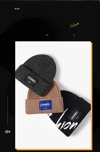 Three knitted winter beanies in dark grey, camel, and black with woven logo labels