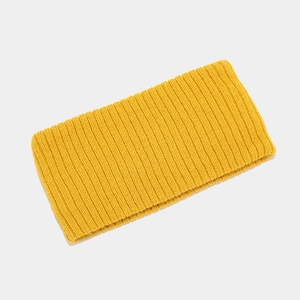 Close-up of bright yellow ribbed knit sports headband showing fabric texture and elasticity