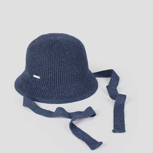 Détail d'un chapeau cloche bleu marine en maille avec de longs rubans et logo argenté
