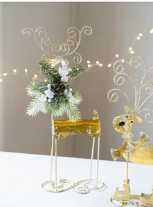 Detail of Christmas iron reindeer decor with gold metal finish and pine cone accents
