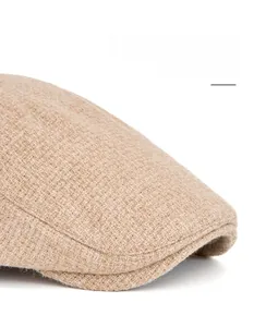 Détail macro de la casquette plate en tweed kaki montrant la texture et le bord pliable