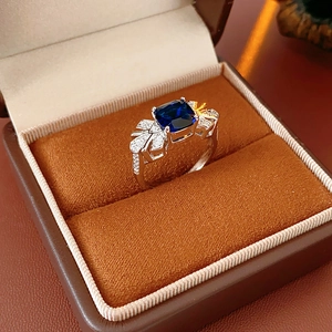 Détail d'une bague style saphir bleu avec accents diamantés dans un écrin à bijoux