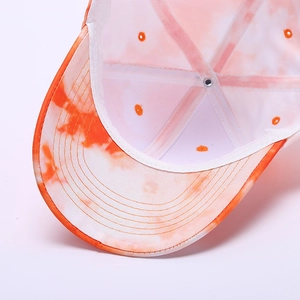 Detail view showing breathable metal eyelets and multi-row stitching on tie-dye baseball cap