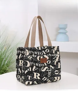 Détail du sac à lunch en tissu Oxford épais avec imprimés de lettres et écusson en cuir