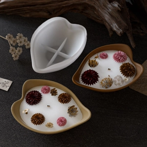 Detail of leaf-shaped silicone mold with finished floral candle and dried flower accents