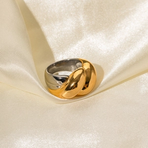 Détail d'une bague bicolore or et argent torsadée sur un tissu en soie élégant