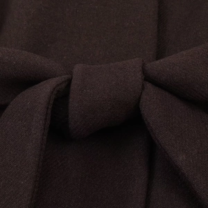 Close-up of deep brown wool coat texture featuring a stylish tied bow belt detail
