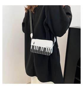 Detail of piano keyboard pattern crossbody bag with I LOVE MUSIC text on PU leather