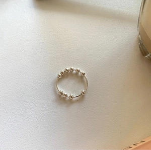 Detail of minimalist 925 sterling silver ring featuring ten sliding rotating beads