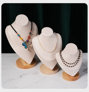 Three-tier beige velvet and beech wood necklace display stands on marble surface