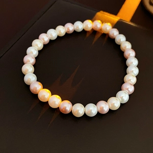 Detailed view of multi-color pearl bracelet on premium dark leather jewelry box