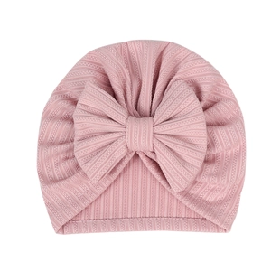 Close-up of pink ribbed knit baby turban hat with a large decorative bow detail