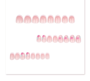 Macro detail of short round press-on nails featuring light pink finish and floral designs