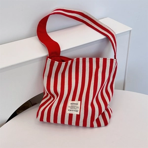 Detailed close-up of red and white striped canvas tote bag with woven brand label