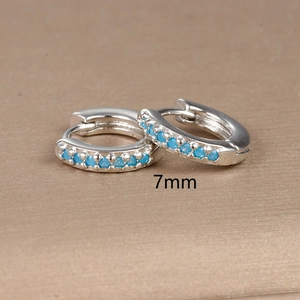 Macro view of 7mm silver hoop earrings featuring pavé-set blue zircon gemstones