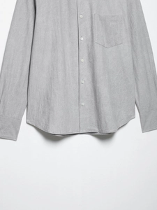 Detail of light grey cotton linen shirt showing chest pocket and fabric texture