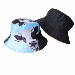 Detail view of double-sided bucket hat featuring light blue cow print and classic black fabric
